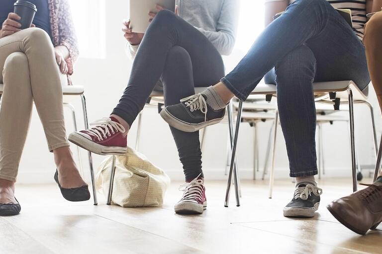 row of legs sitting together, inferring a group counseling session